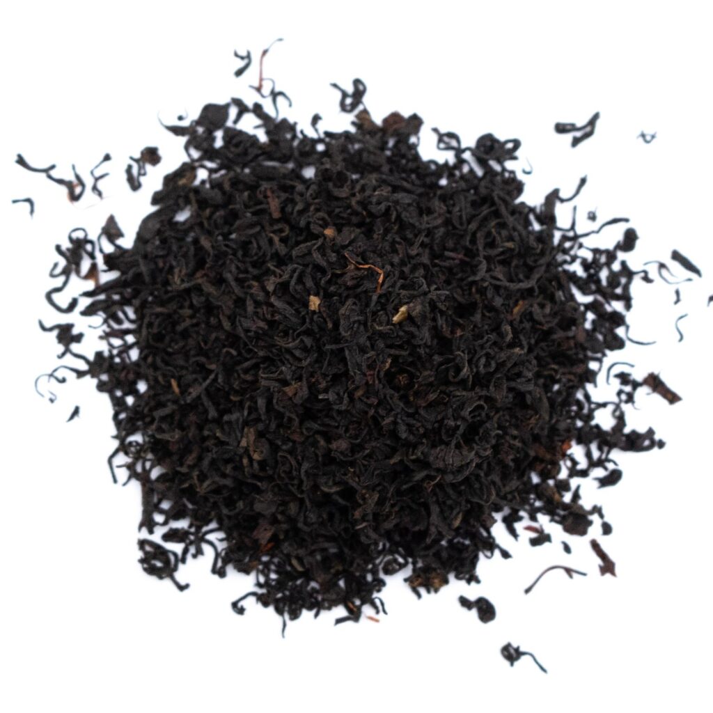 A pile of loose blueberry tea leaves arranged on a white background.