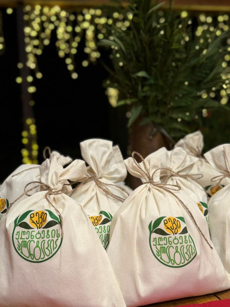 Fabric pouches containing Georgian tea bags with a green logo and tied with twine.