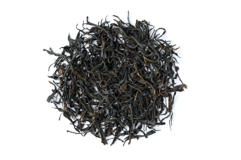 Dried dark oolong tea leaves arranged in a circular shape on a white background.